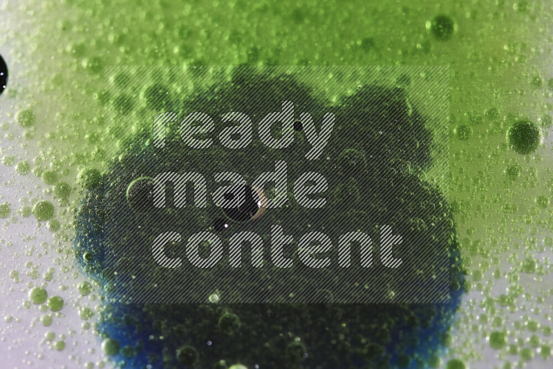 Close-ups of abstract green and blue watercolor drops on oil Surface on white background