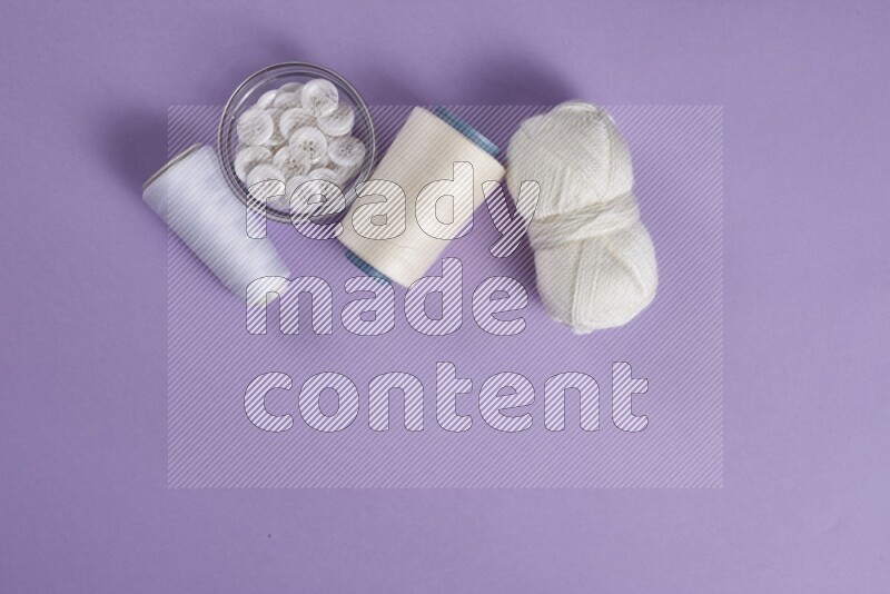 A white and purple collection of sewing and tailoring tools arranged on a purple background