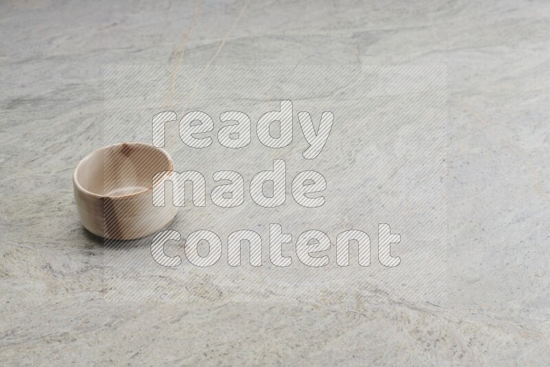 A multicolored pottery bowl on grey marble background