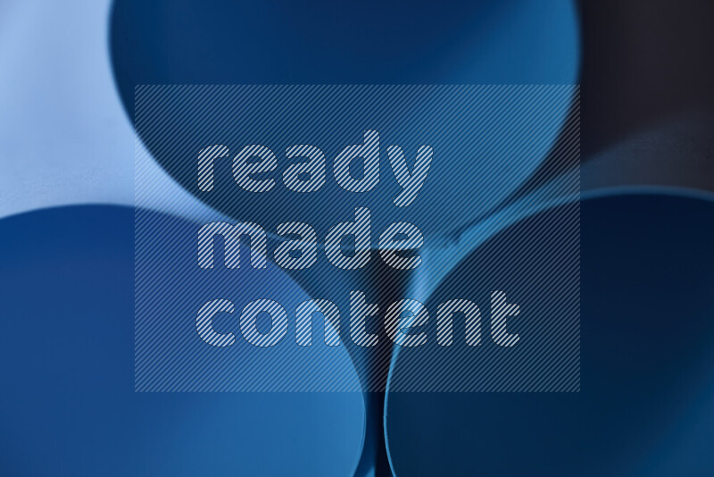 The image shows an abstract paper art with circular shapes in varying shades of blue