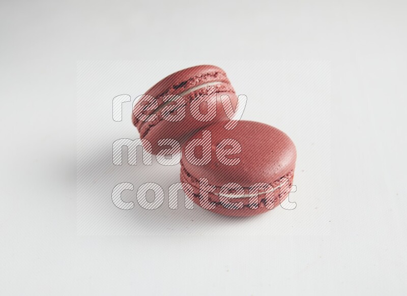 45º Shot of two Red Velvet macarons on white background