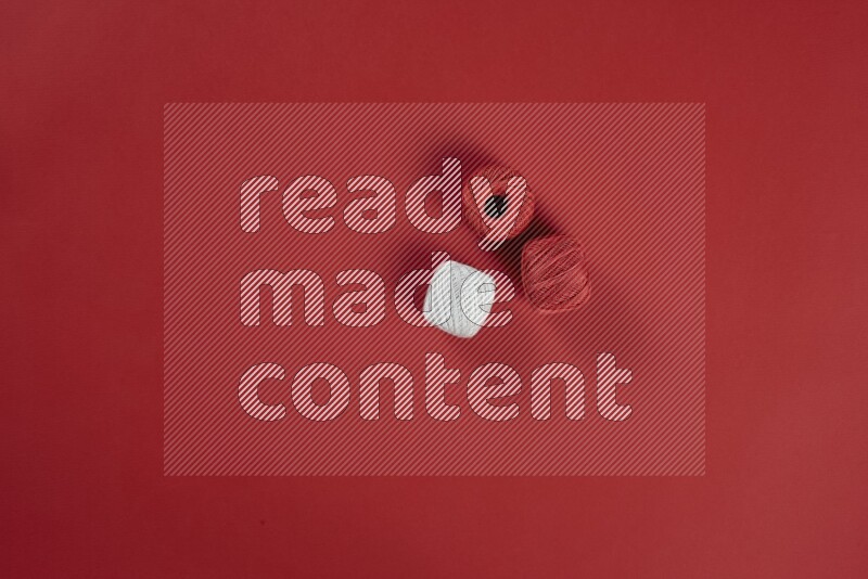 مجموعة من أدوات الخياطة والتفصيل بيضاء اللون على خلفية حمراء