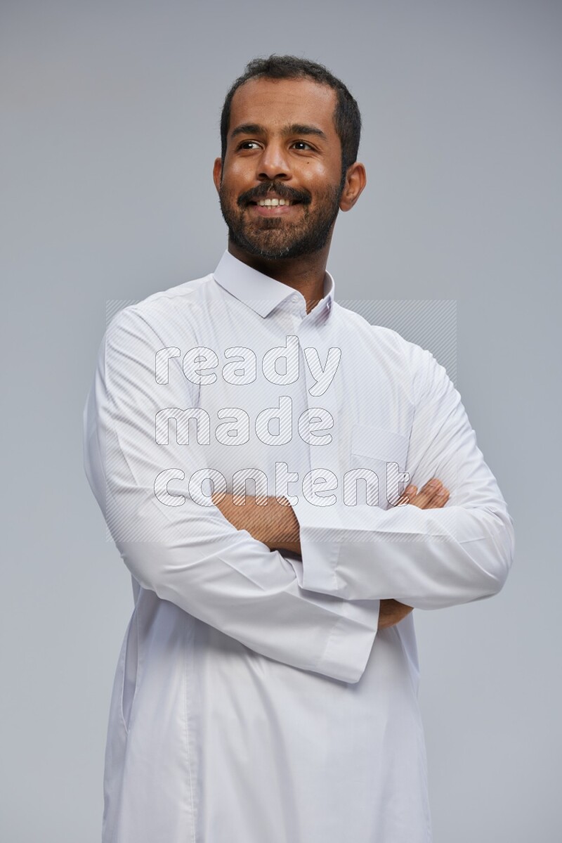 Saudi man wearing Thob standing with crossed arms on Gray background
