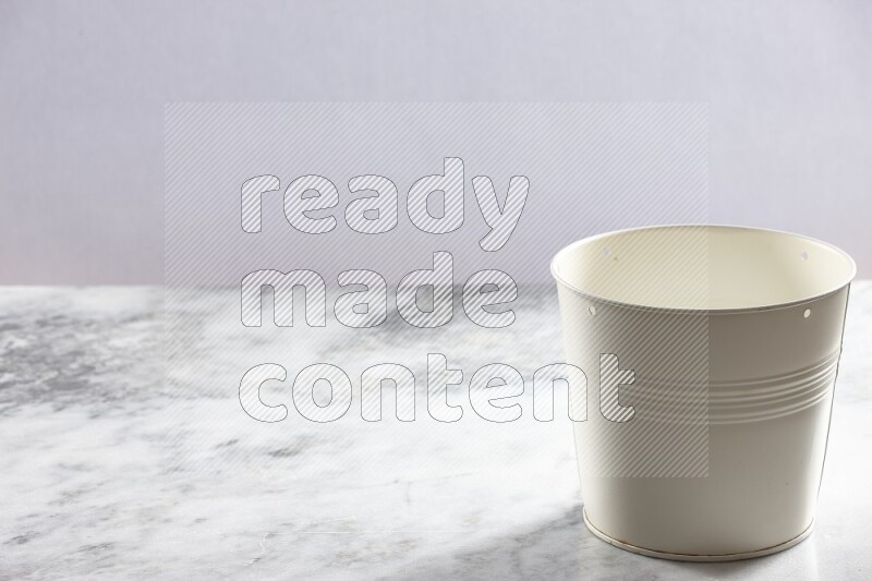 An empty white plant pot on grey marble background