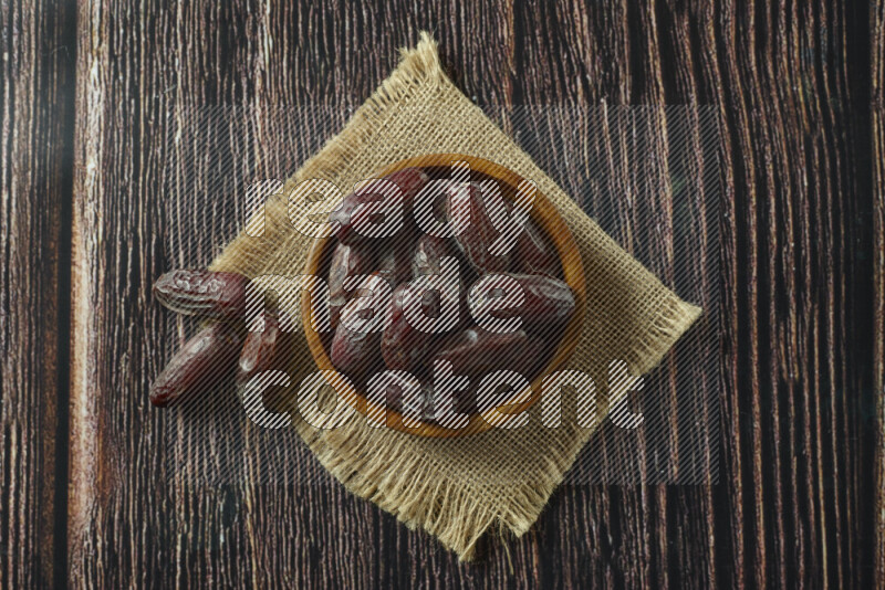Dates in different bowls (wooden, pottery and glass) on wooden background