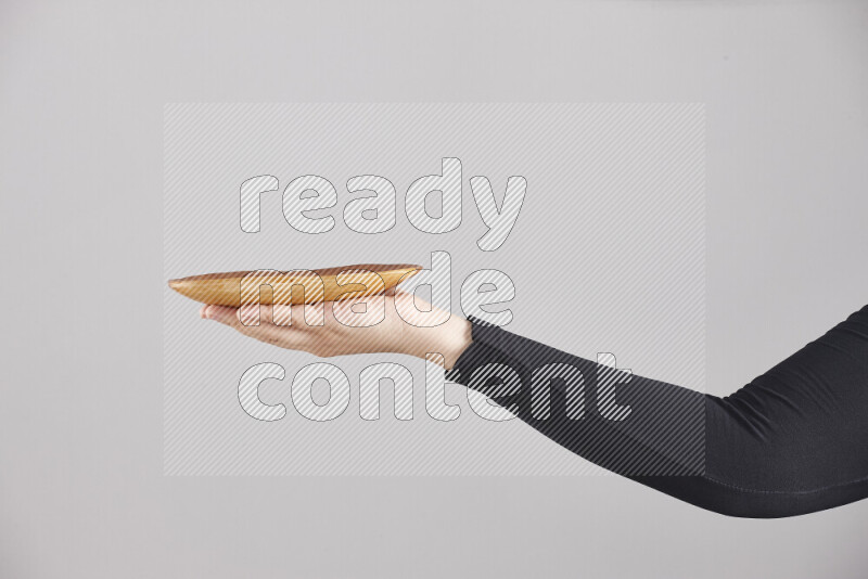 امرأة ترتدي عباءة سوداء تحمل أدوات خشبية مختلفة في أوضاع متعددة