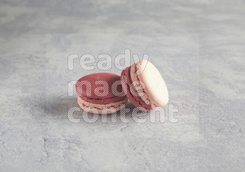 45º Shot of two Pink Litchi Raspberry macarons  on white  marble background