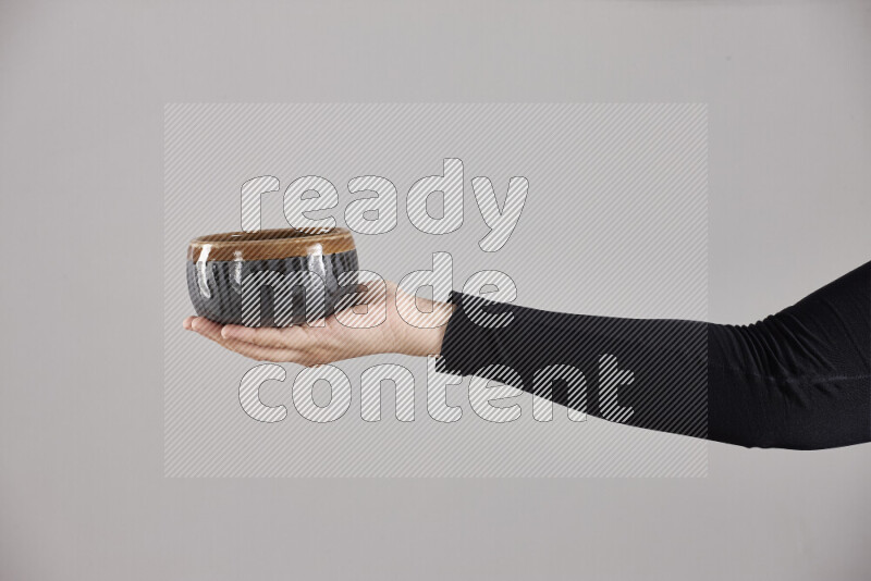 امرأة ترتدي عباءة سوداء تحمل أدوات فخارية مختلفة في أوضاع متعددة