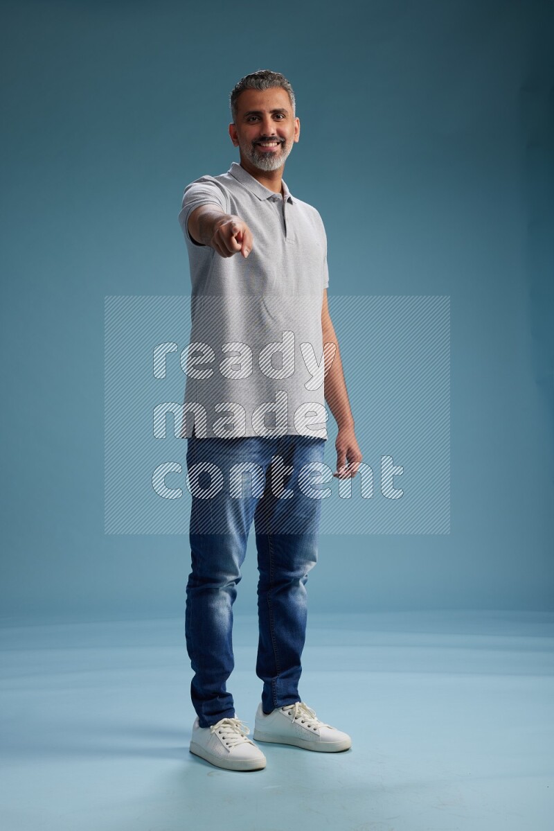 Man Standing Interacting with the camera on blue background