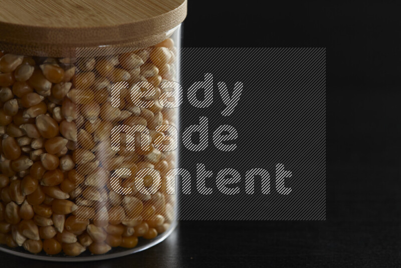 Pop corn in a glass jar on black background