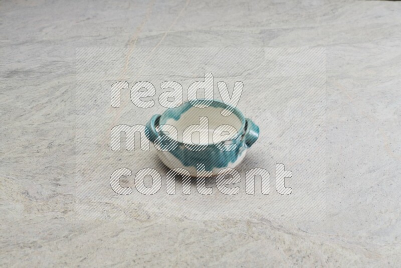 A multicolored pottery bowl on grey marble background