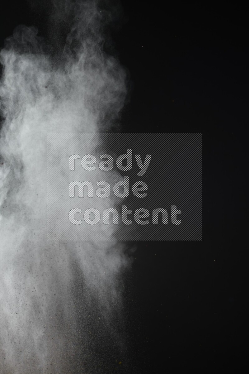 A side view of brown powder explosion on black background