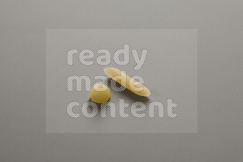 Shells pasta with other types of pasta on grey background