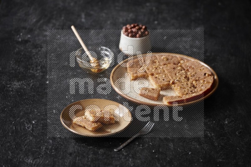 Basbousa with nuts and honey in a dark setup
