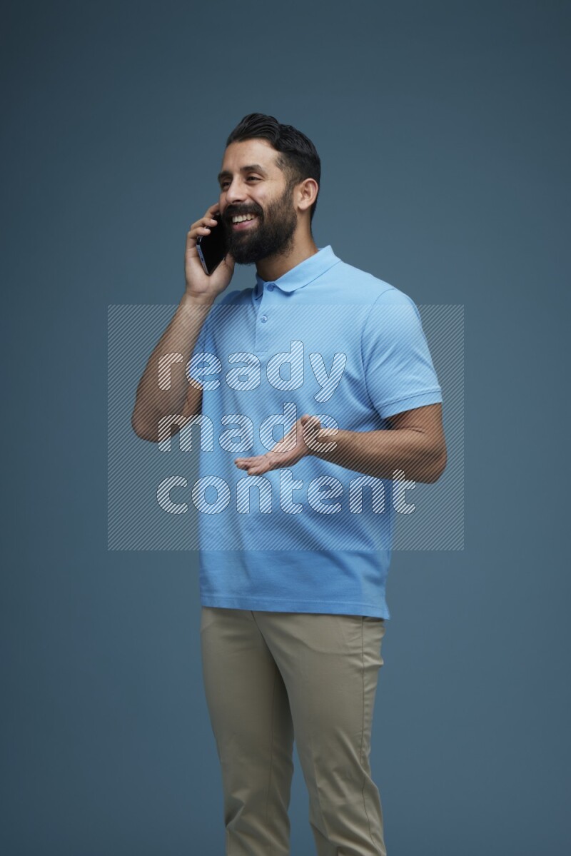 A man having a Call in a blue background wearing a Blue shirt