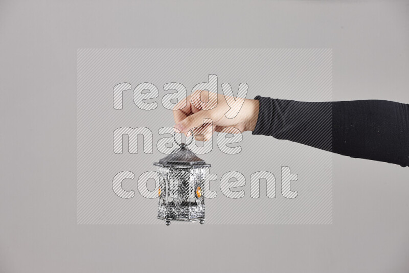 A woman in black abaya holding different ramadan lanterns in different positions