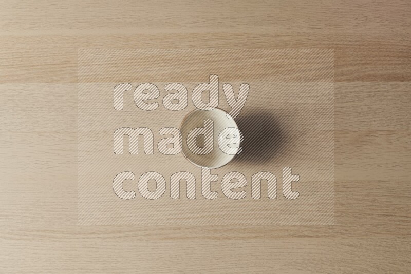 A white pottery bowl on light wooden background
