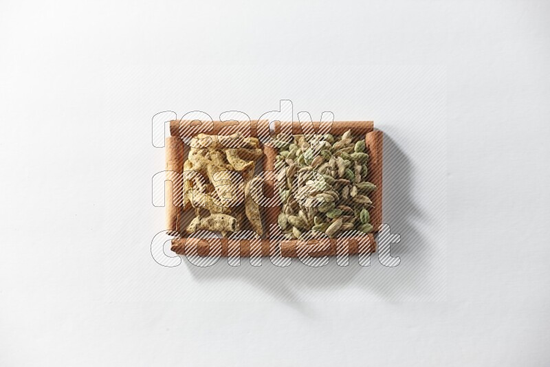 2 squares of cinnamon sticks full of cardamom and turmeric fingers on white flooring