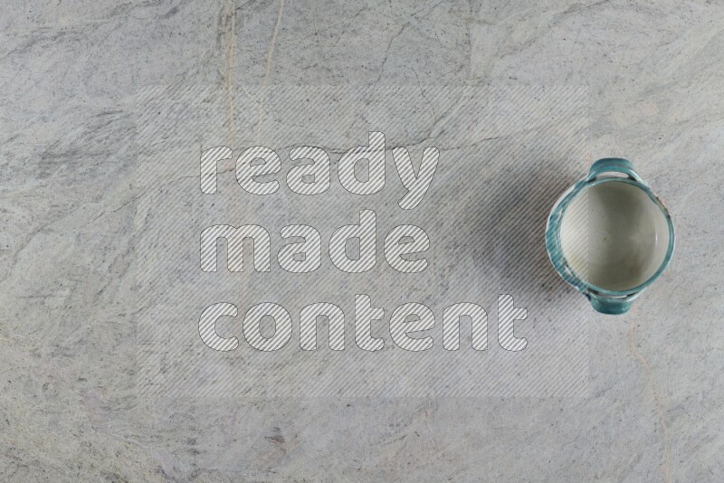 وعاء فخاري متعدد الألوان على خلفية من الرخام الرمادي