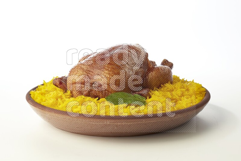 yellow basmati Rice with whole roasted chicken  on a pottery plate  direct  on white background