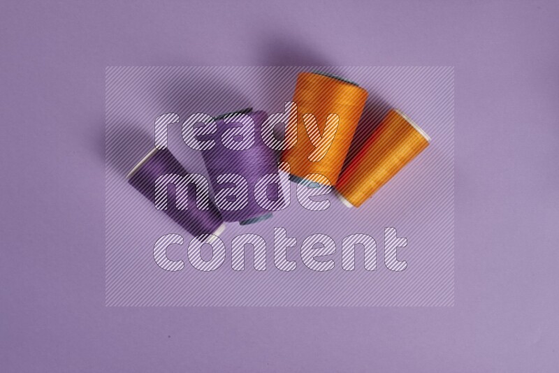 An orange collection of sewing and tailoring tools arranged on a purple background