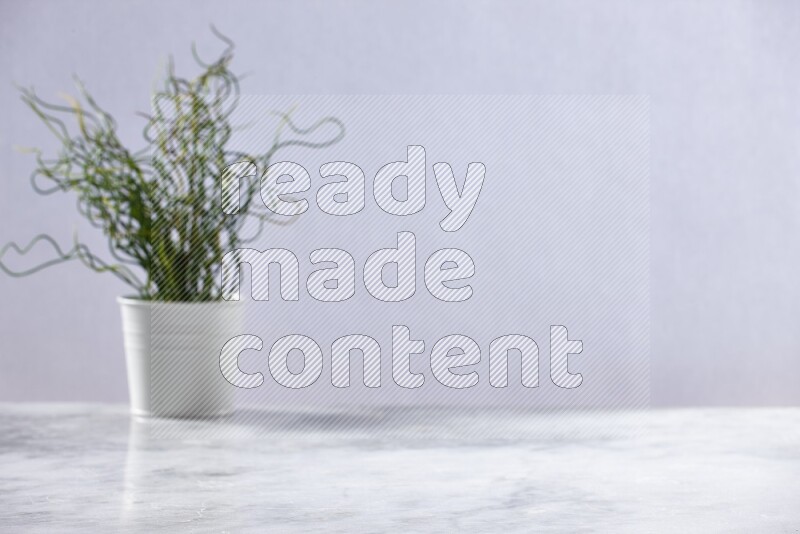 Artificial plant in white pot on grey marble background