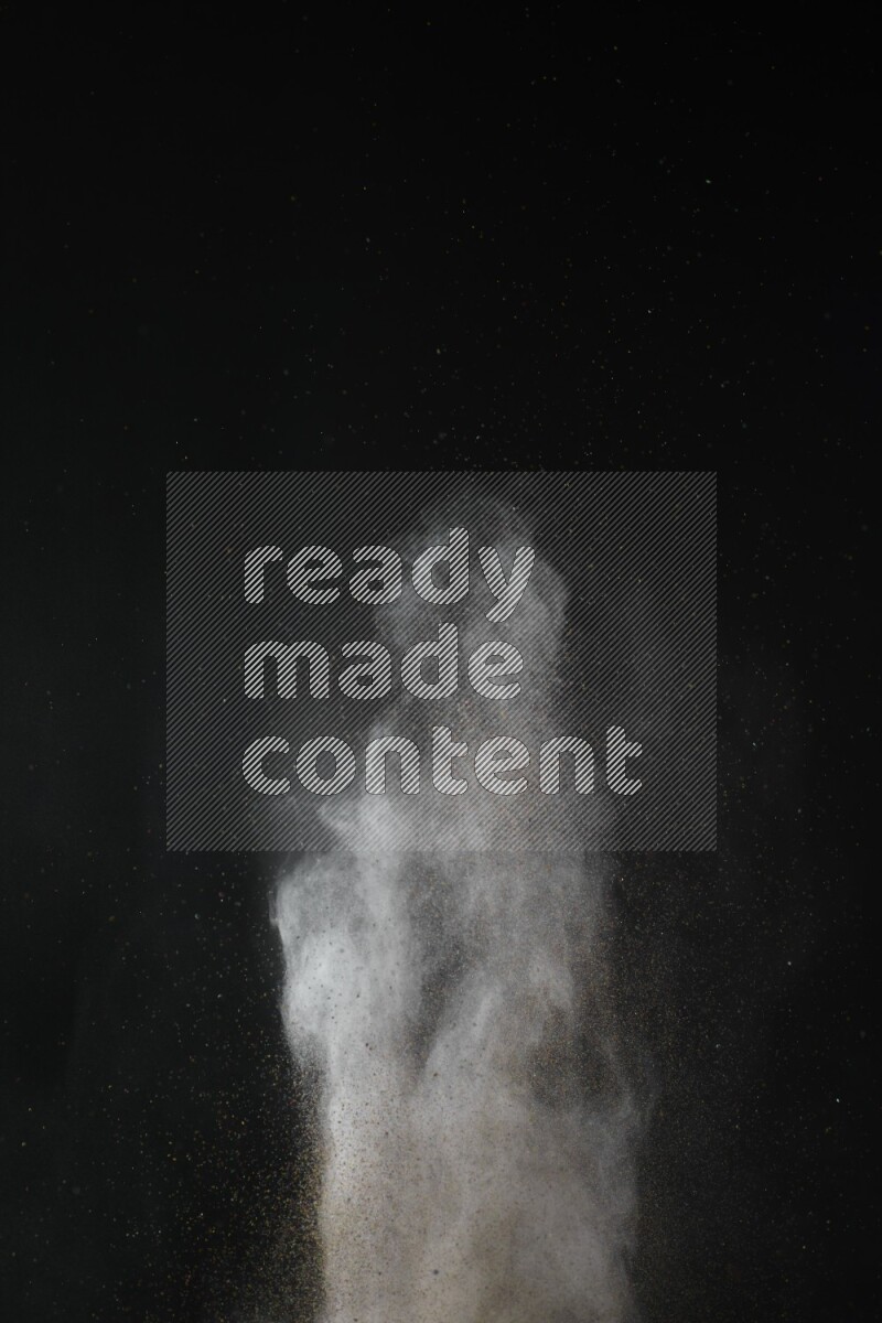 A side view of brown powder explosion on black background