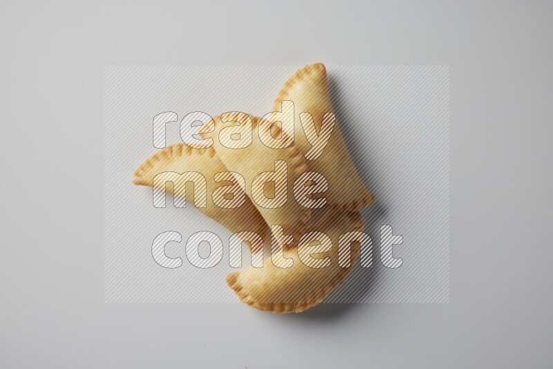 Four fried sambosa from a top angle on a white background