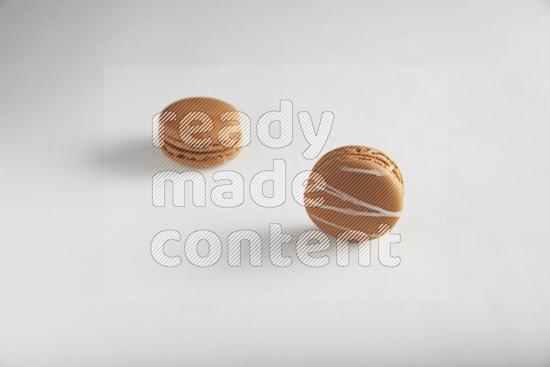 45º Shot of of two assorted Brown Irish Cream, and Brown Coffee macarons  on white background