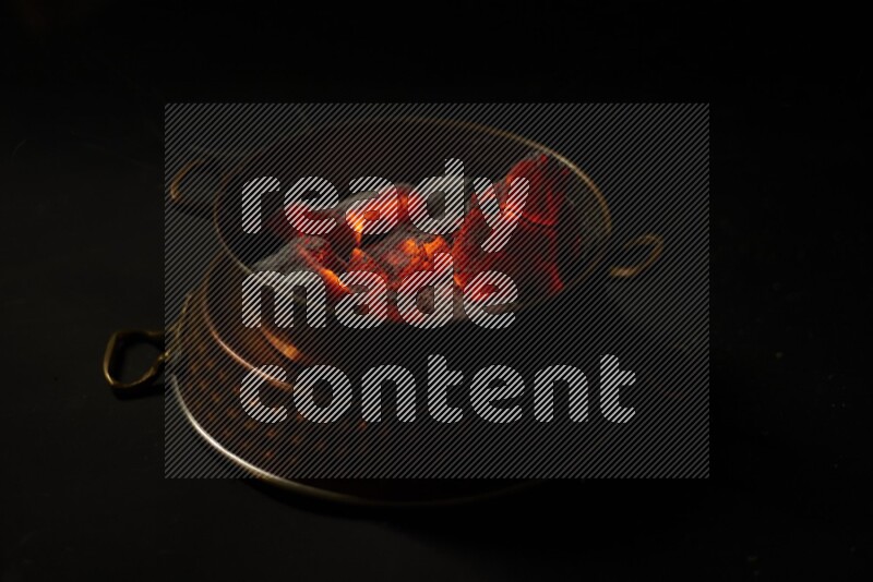 Coal cubes on fire in metal pan