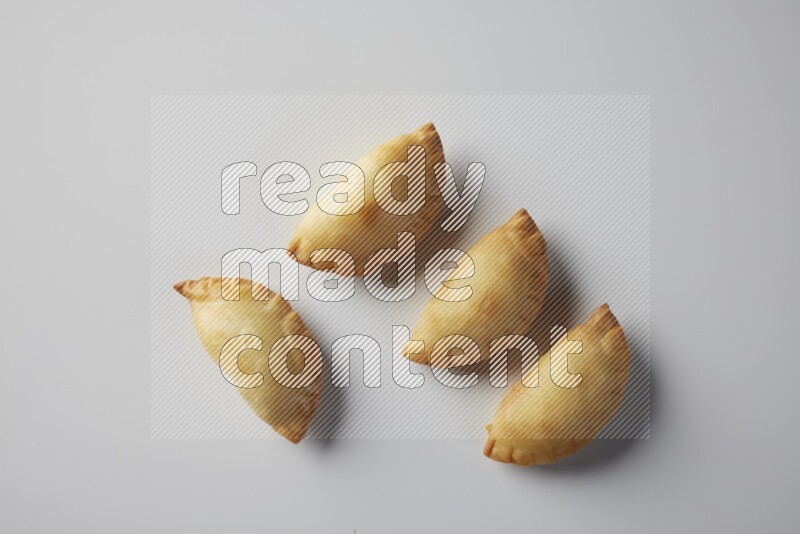 Four fried sambosa from a top angle on a white background