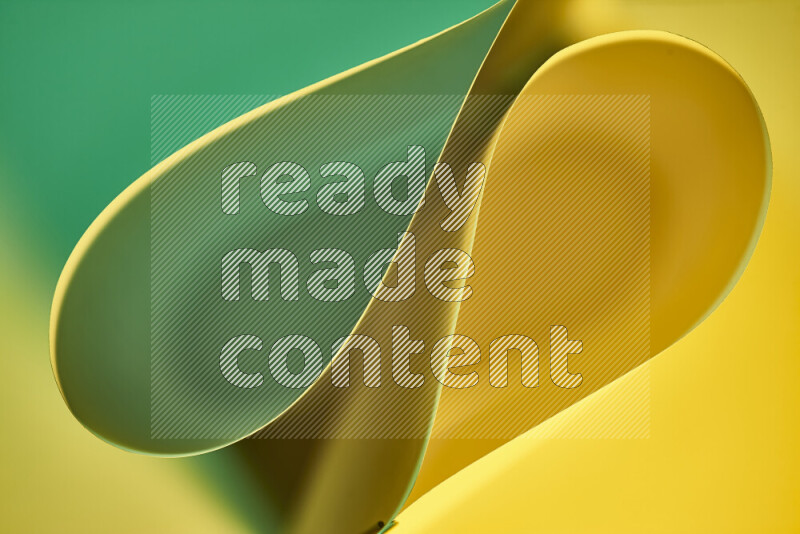 An abstract art of paper folded into smooth curves in green and yellow gradients