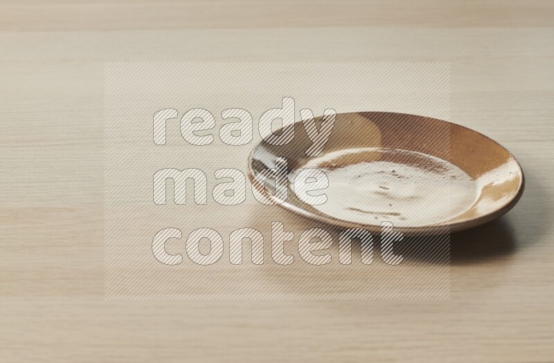 A multicolored pottery plate on light wooden background