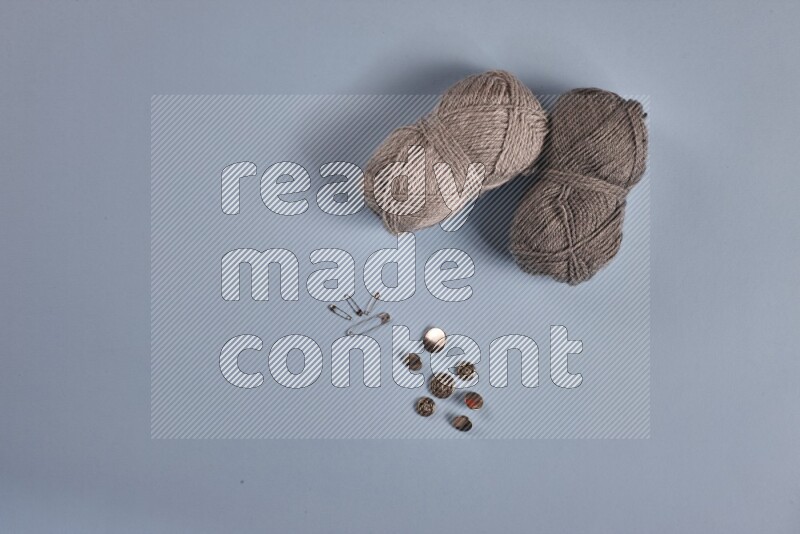 A grey collection of sewing and tailoring tools arranged on a blue background