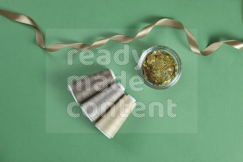 A brown collection of sewing and tailoring tools arranged on a green background