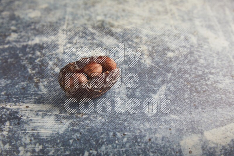 hazelnuts stuffed majdoul date on a rustic blue background