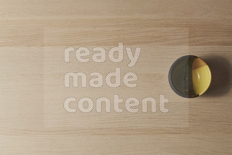 وعاء فخاري متعدد الألوان على خلفية خشبية فاتحة