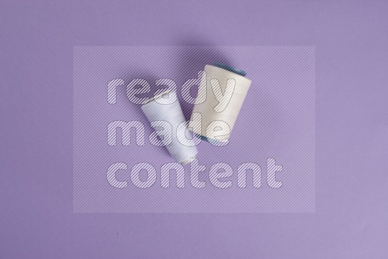 A white and purple collection of sewing and tailoring tools arranged on a purple background