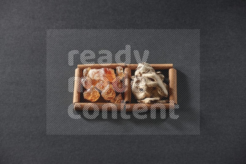 2 squares of cinnamon sticks full of dried ginger and gum arabic on black flooring