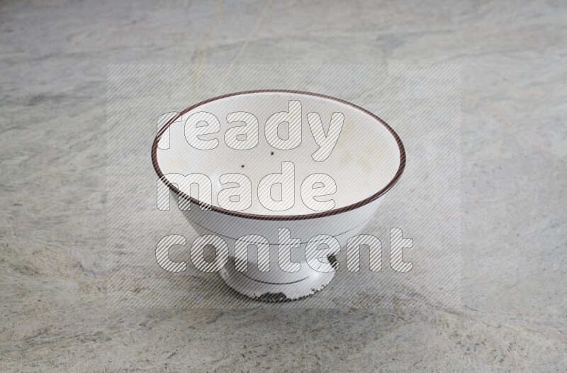 A vintage metal pot on grey marble background