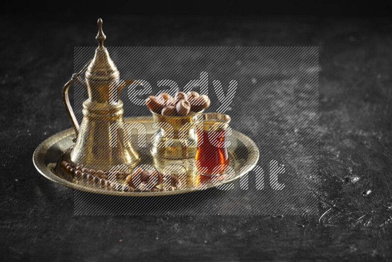 Dates with a drink on a metal tray in a dark setup