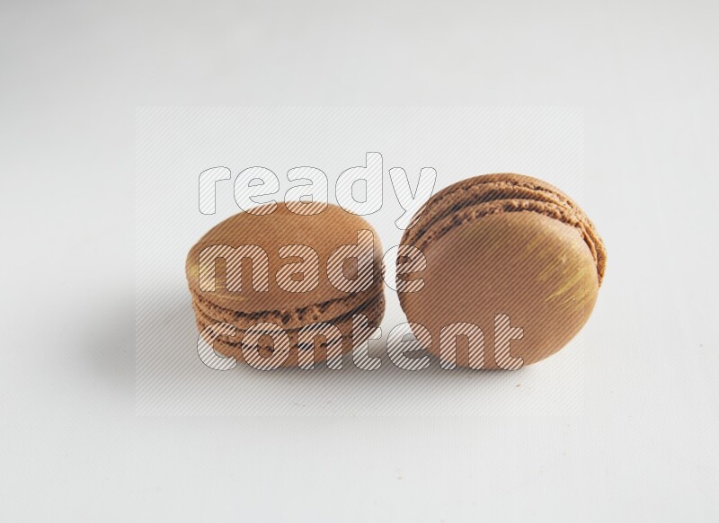 45º Shot of two Brown Coffee macarons on white background