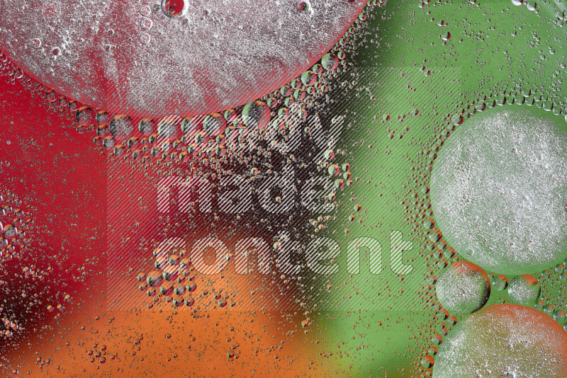 Close-ups of abstract oil bubbles on water surface in shades of orange, green and red