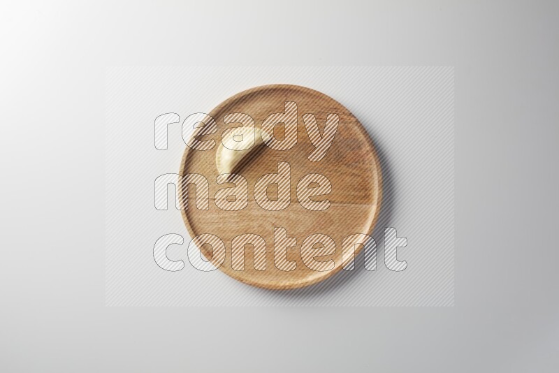 A single Sambosa on a wooden round plate on a white background