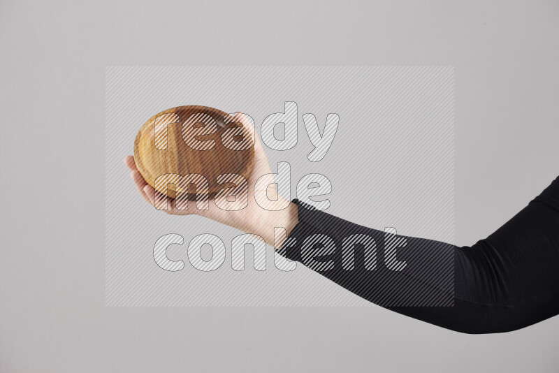 امرأة ترتدي عباءة سوداء تحمل أدوات خشبية مختلفة في أوضاع متعددة