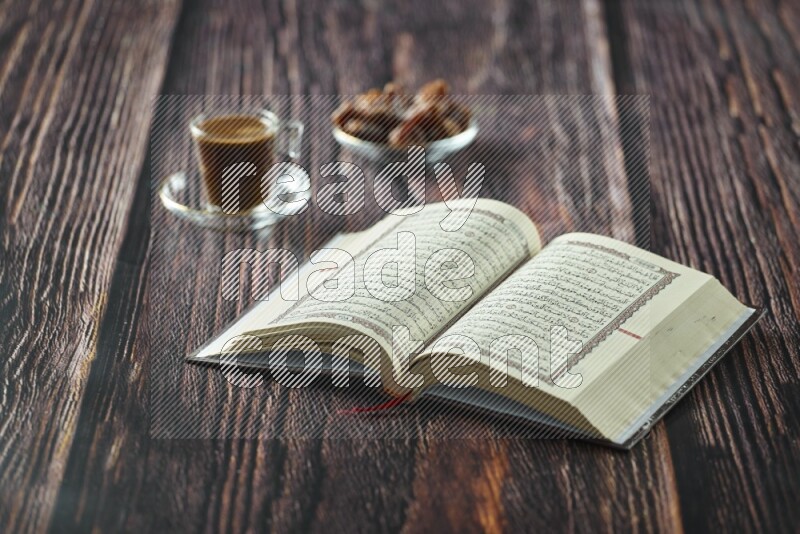 Quran with dates, prayer beads and different drinks all placed on wooden background