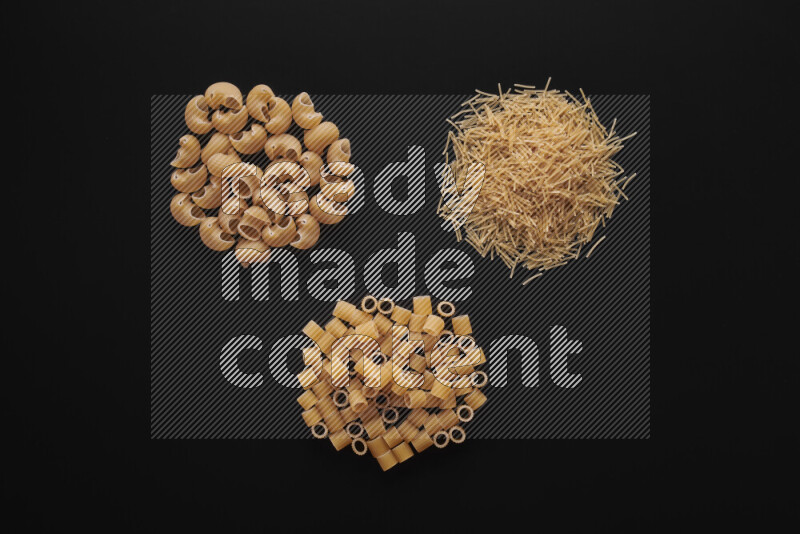 Different pasta types in bunches on black background