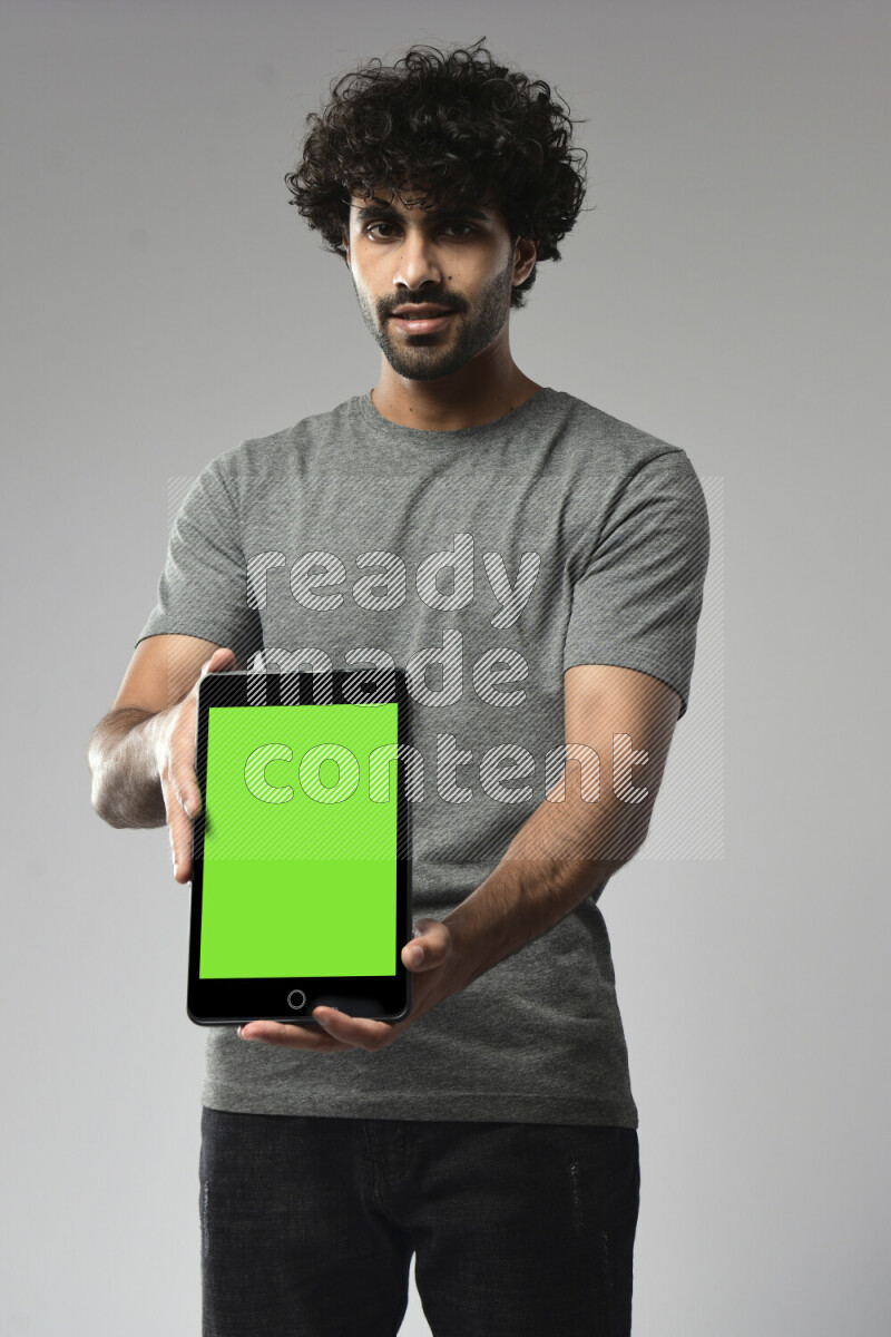 A man wearing casual standing and showing a tablet screen on white background