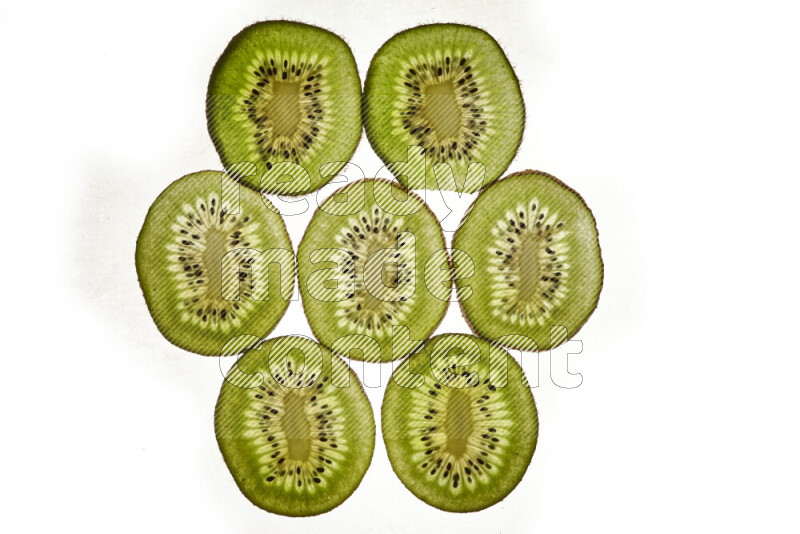 Kiwi slices on illuminated white background
