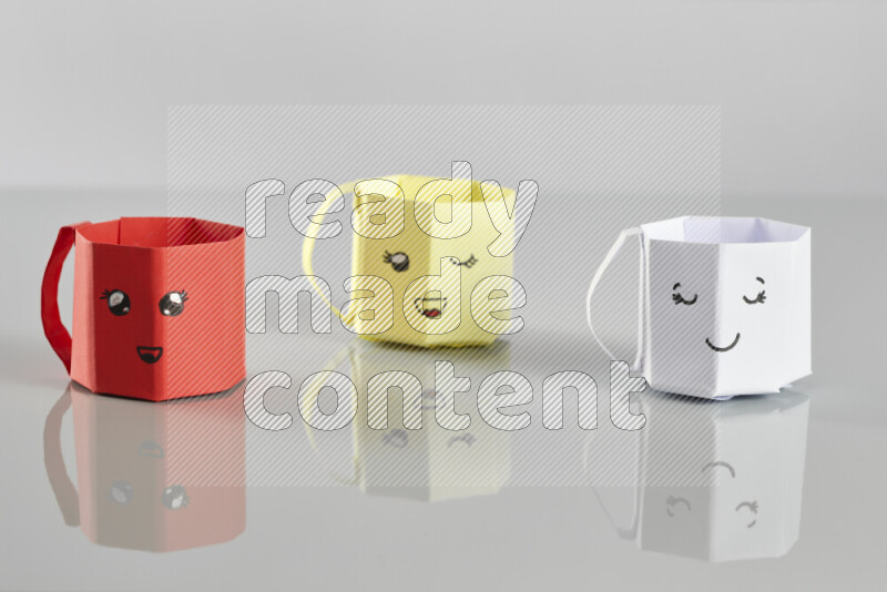 Origami cup on grey background